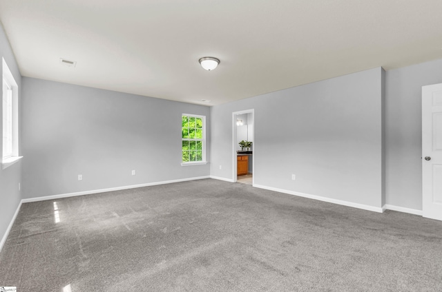 carpeted empty room with baseboards