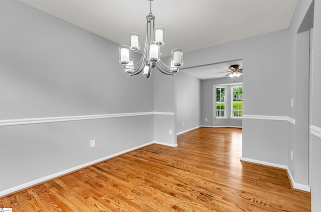 empty room featuring baseboards, light wood-style flooring, and ceiling fan with notable chandelier