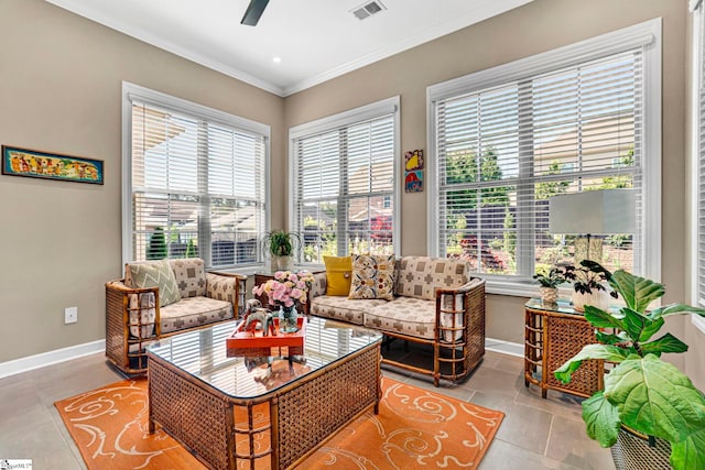 living area featuring crown molding, a ceiling fan, baseboards, and visible vents