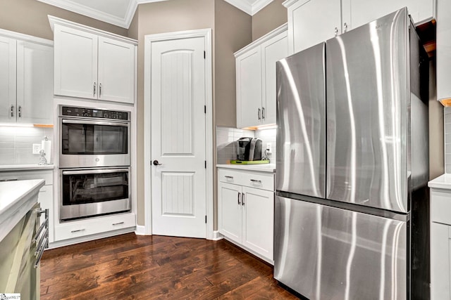 kitchen featuring dark wood-style flooring, appliances with stainless steel finishes, ornamental molding, and tasteful backsplash