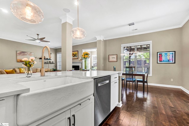kitchen with crown molding, a sink, dark wood finished floors, a ceiling fan, and stainless steel dishwasher