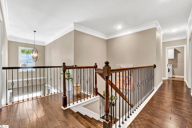 corridor featuring washer / dryer, a chandelier, hardwood / wood-style flooring, and an upstairs landing