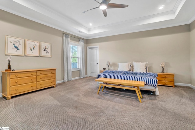 bedroom featuring baseboards, light colored carpet, ornamental molding, and a raised ceiling