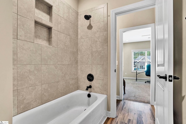 full bathroom with baseboards, tub / shower combination, and wood finished floors