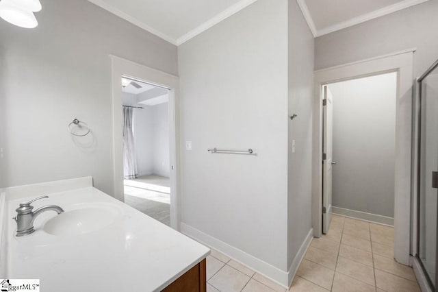 bathroom featuring tile patterned flooring, ornamental molding, baseboards, and vanity