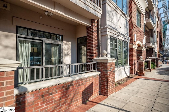 doorway to property featuring brick siding and stucco siding