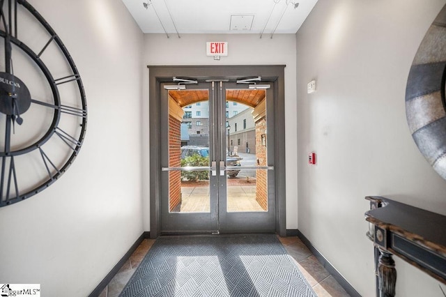 doorway featuring baseboards, french doors, and tile patterned floors