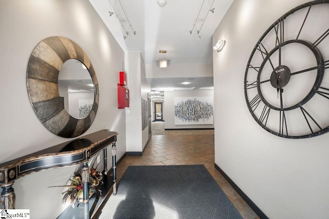 hallway with baseboards and tile patterned floors