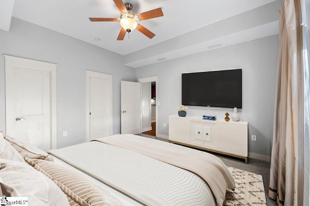 carpeted bedroom featuring baseboards, ceiling fan, and visible vents