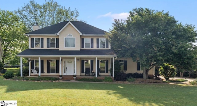 colonial-style house with a porch, a front lawn, and a chimney