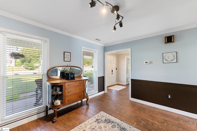 interior space with baseboards, ornamental molding, wood-type flooring, and visible vents