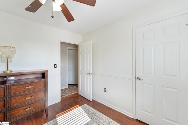 bedroom with baseboards, dark wood-style flooring, and ceiling fan