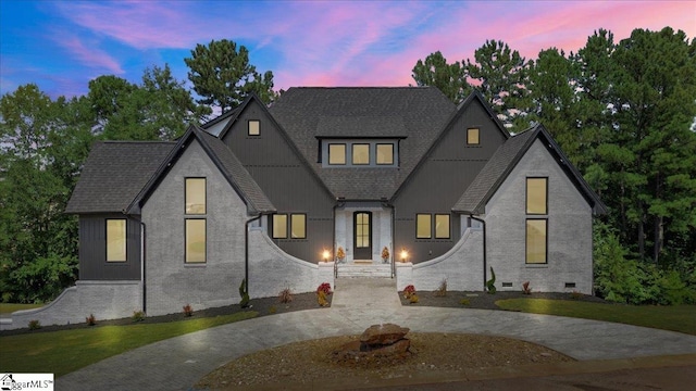 modern farmhouse with roof with shingles, board and batten siding, crawl space, and brick siding