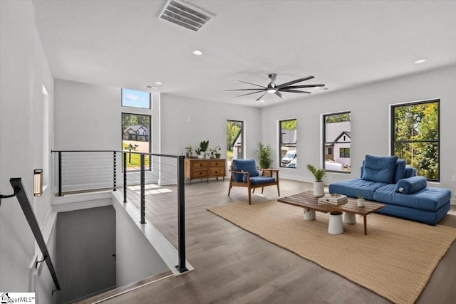 living room with ceiling fan, recessed lighting, wood finished floors, and visible vents