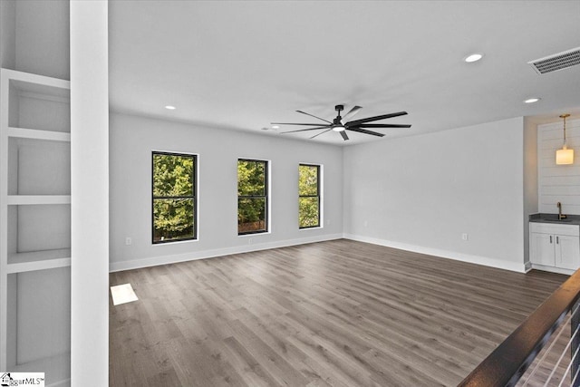 unfurnished living room with recessed lighting, ceiling fan, visible vents, and wood finished floors