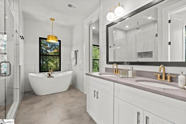 full bath with a wainscoted wall, visible vents, a sink, and a stall shower