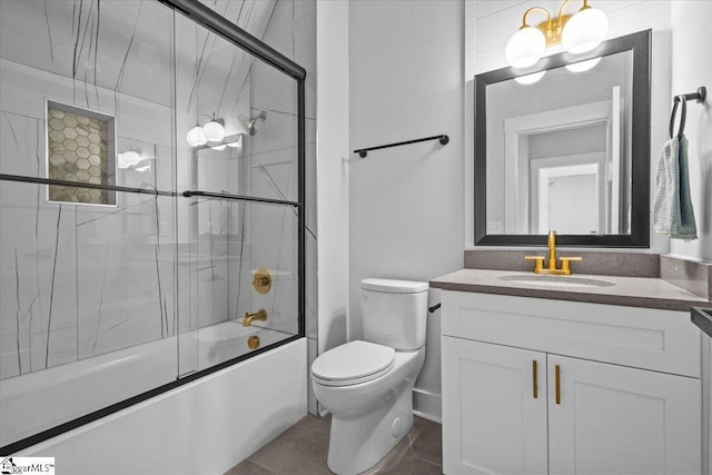 bathroom featuring vanity, shower / bath combination with glass door, tile patterned flooring, and toilet