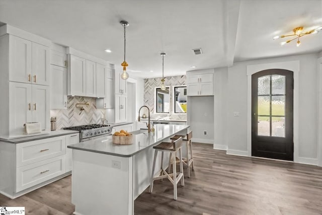 kitchen featuring a sink, arched walkways, tasteful backsplash, and range