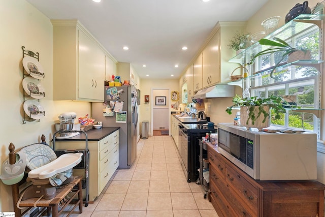 kitchen featuring recessed lighting, light tile patterned floors, cream cabinetry, under cabinet range hood, and stainless steel refrigerator with ice dispenser