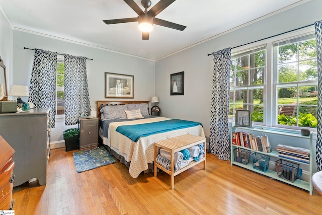 bedroom with crown molding, ceiling fan, and wood finished floors
