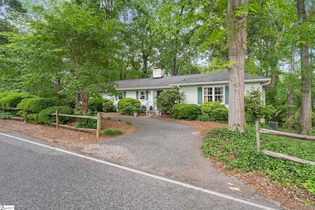ranch-style house featuring driveway and a chimney
