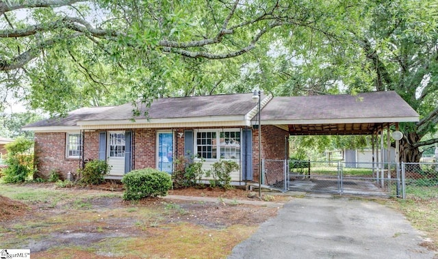 single story home featuring fence, an attached carport, brick siding, a gate, and driveway