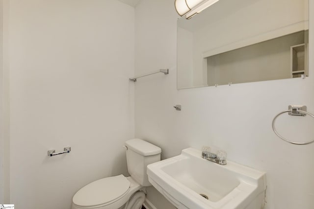 half bathroom featuring a sink and toilet