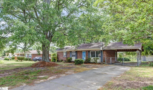 ranch-style house with driveway, a gate, brick siding, fence, and an attached carport