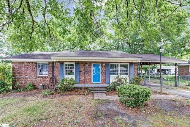 single story home with brick siding, a gate, fence, and an attached carport