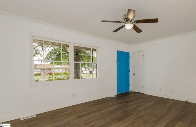 spare room with dark wood-style floors, ornamental molding, and plenty of natural light