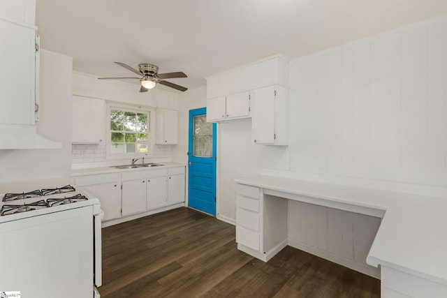 kitchen with white gas range, ceiling fan, a sink, white cabinetry, and dark wood-type flooring