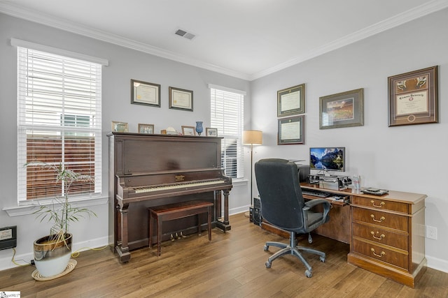 home office featuring crown molding, baseboards, wood finished floors, and visible vents