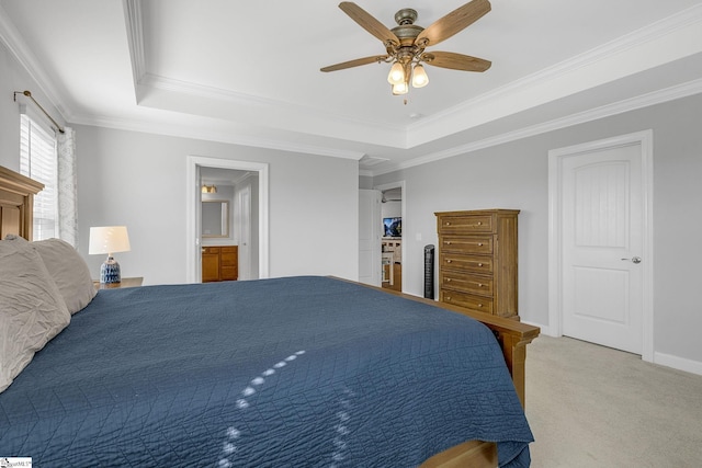bedroom featuring ceiling fan, light carpet, ensuite bath, a tray ceiling, and ornamental molding