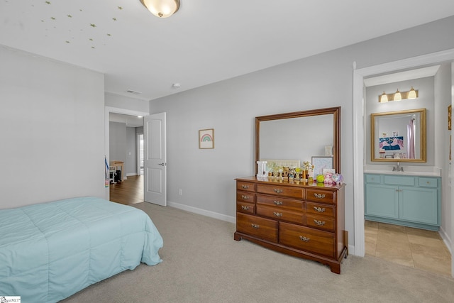bedroom with light carpet, a sink, baseboards, ensuite bathroom, and visible vents