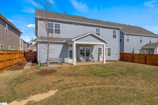 rear view of house with a yard, a patio, and a fenced backyard