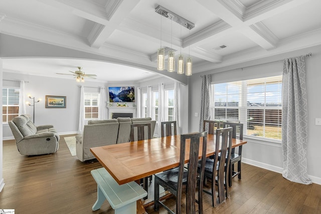 dining room featuring baseboards, dark wood-style floors, a fireplace, and beamed ceiling