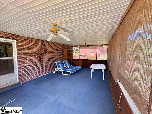 unfurnished sunroom with a ceiling fan