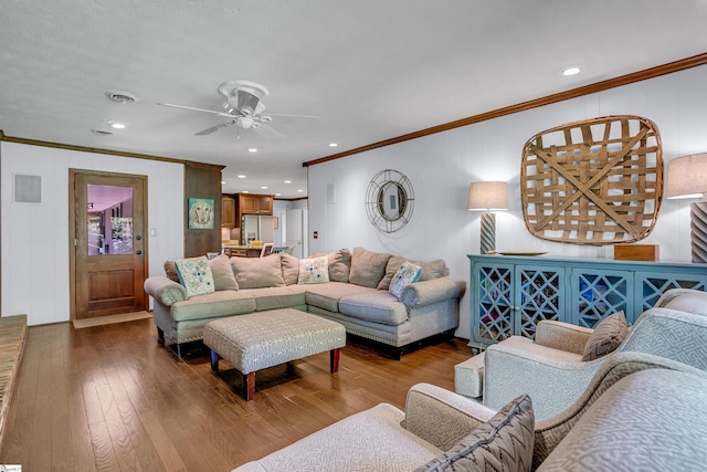 living area with crown molding, a ceiling fan, and wood-type flooring