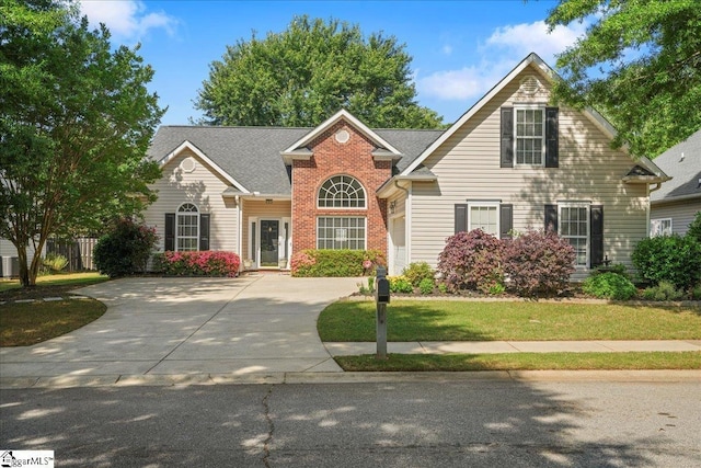 traditional home with concrete driveway and a front yard