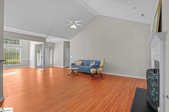 sitting room with light wood finished floors, a ceiling fan, high vaulted ceiling, a fireplace with flush hearth, and visible vents
