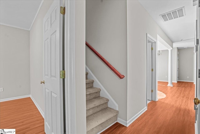hallway with light wood-style flooring, baseboards, and visible vents