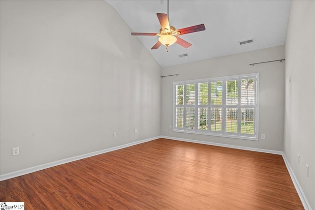 empty room with wood finished floors, a ceiling fan, high vaulted ceiling, visible vents, and baseboards