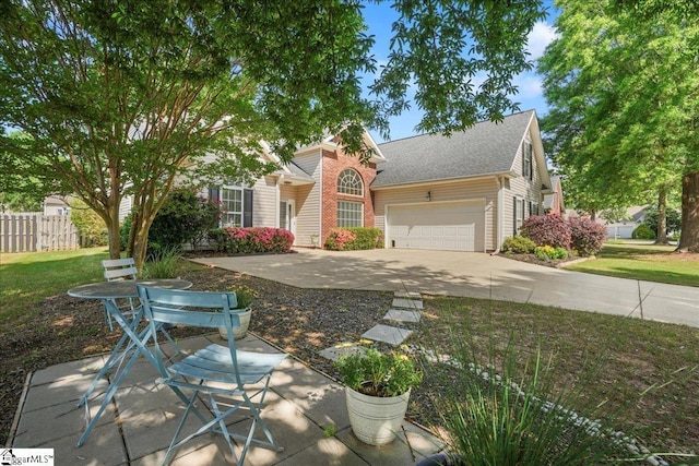 view of front facade with fence, an attached garage, concrete driveway, a front lawn, and a shingled roof