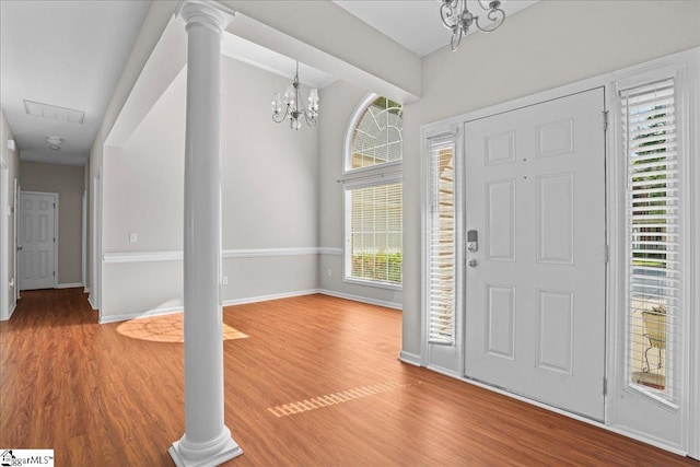 entrance foyer featuring a chandelier, a healthy amount of sunlight, and wood finished floors