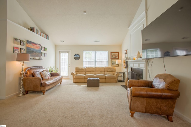 carpeted living room with visible vents, baseboards, a fireplace, and lofted ceiling