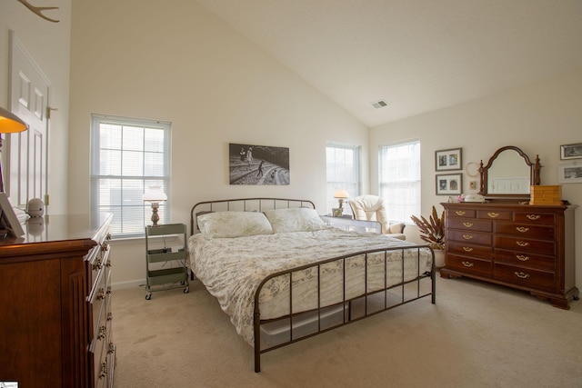 bedroom with light carpet, baseboards, visible vents, and high vaulted ceiling