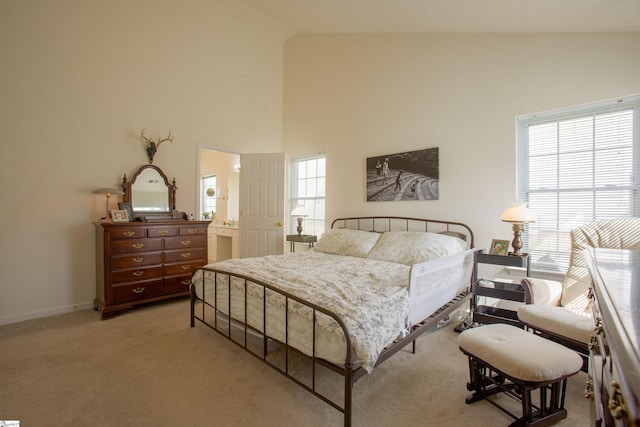 bedroom featuring light colored carpet, baseboards, and high vaulted ceiling