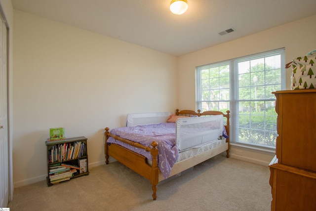 carpeted bedroom with baseboards, multiple windows, and visible vents