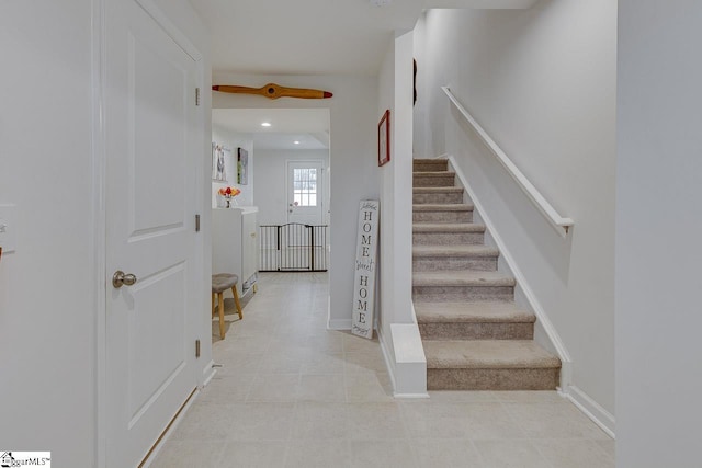 stairs with baseboards and recessed lighting