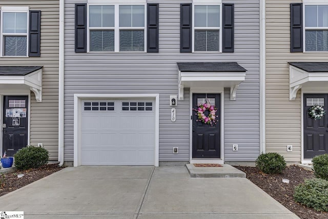 property entrance featuring concrete driveway and a garage